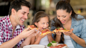 Familia celíaca comiendo pizza fuera de casa